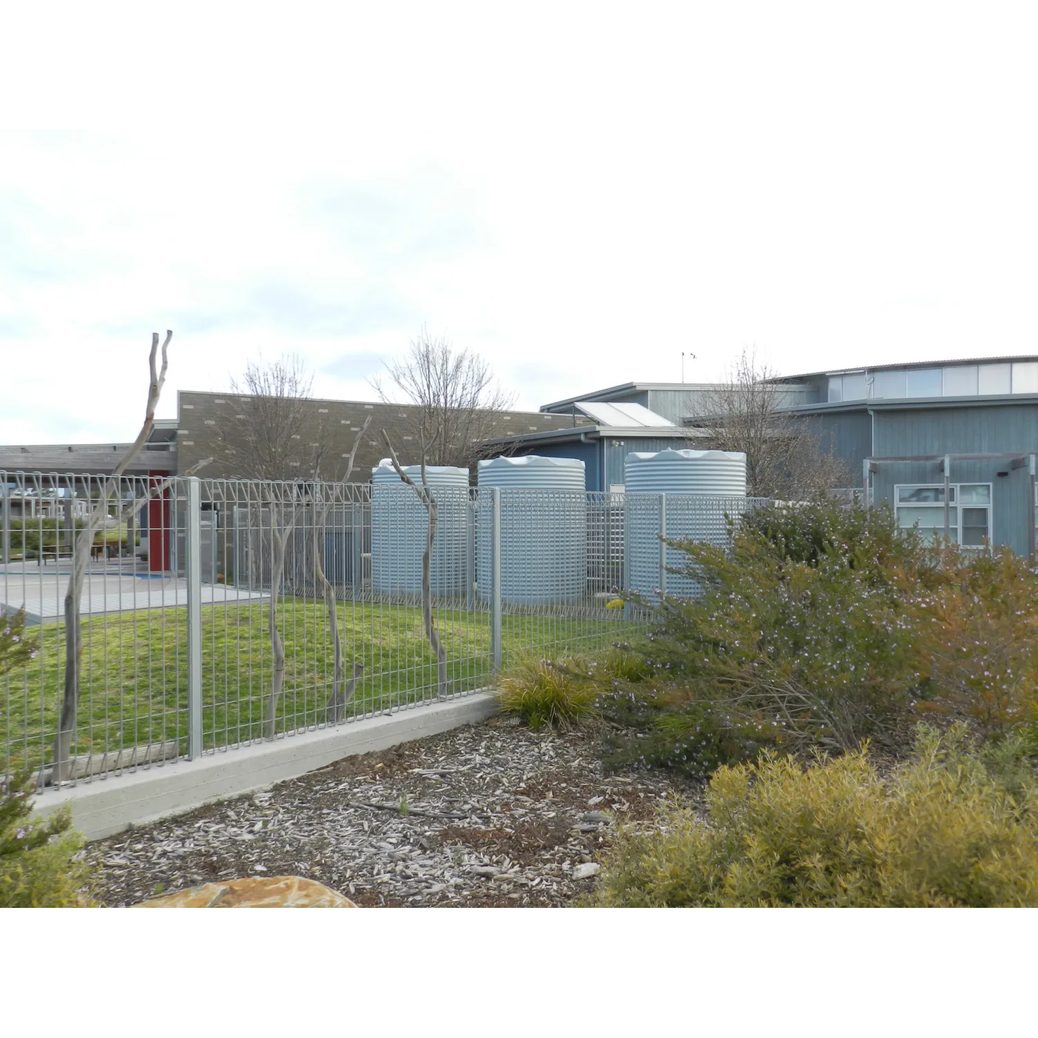Three Orion Australia 4600 Ltr Corrugated Rainwater Tanks in a school
