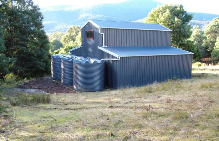 Three 11250 Ltr Corrugated Rainwater Tanks by Orion Australia matching existing Colorbond® house colours.