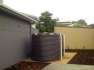 11250 Ltr Corrugated Rainwater Tank matching Colorbond® home with gravel and concrete