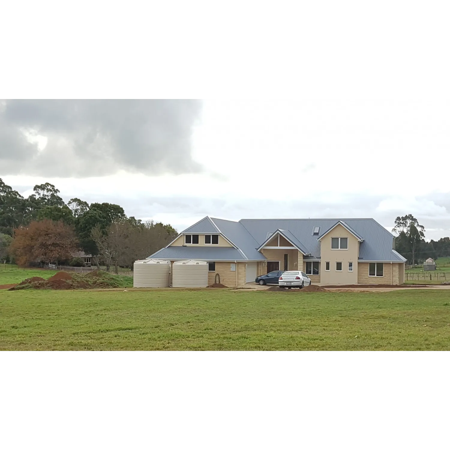 22000 Ltr Panelled Wall Rainwater Tank on a Colorbond® home with bricks and render