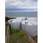 Four 22000 Ltr Panelled Wall Rainwater Tanks sitting beach side.