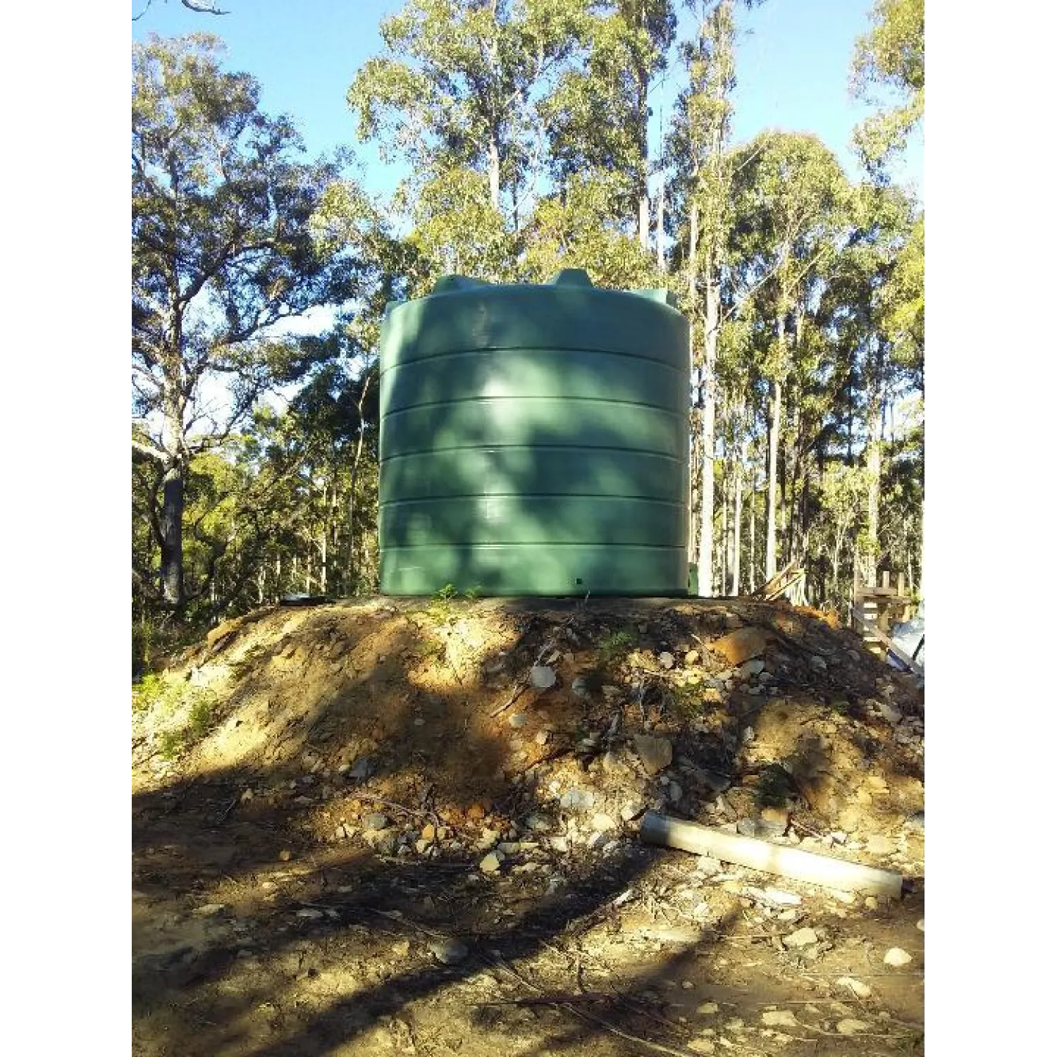 26000 Ltr Panelled Wall Rainwater Tank sitting on raised earth base.