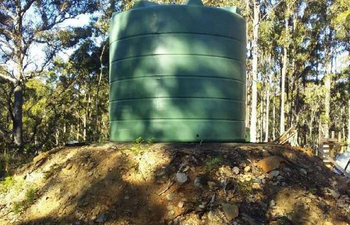 26000 Ltr Panelled Wall Rainwater Tank sitting on raised earth base.