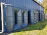 Three 3000 Ltr Slimline Rainwater Tanks joined by tap/valve next to blue shed